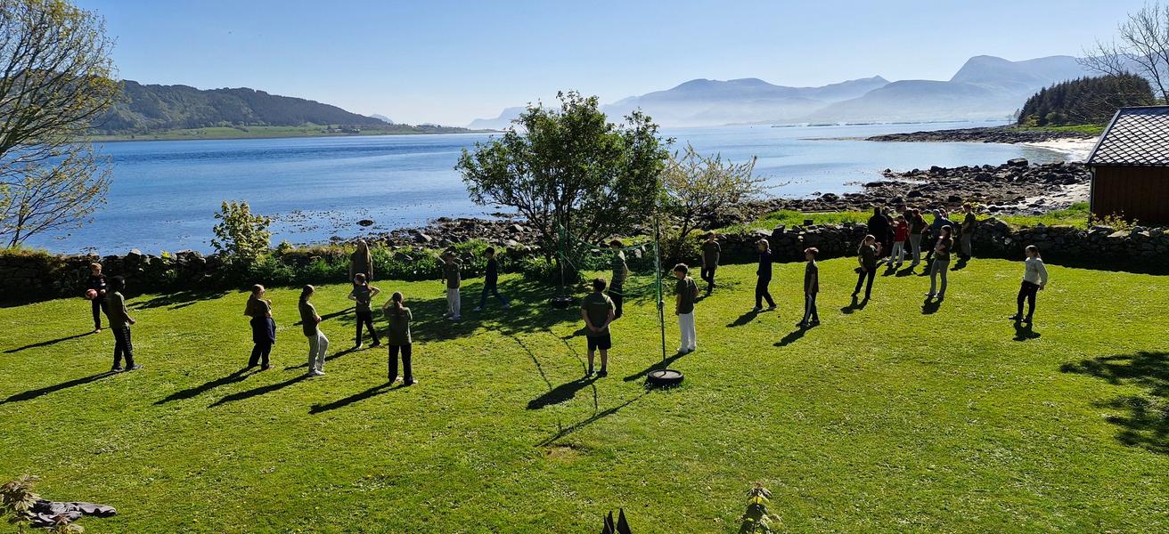 Ungdommer på gressplen ved strand i godt vær