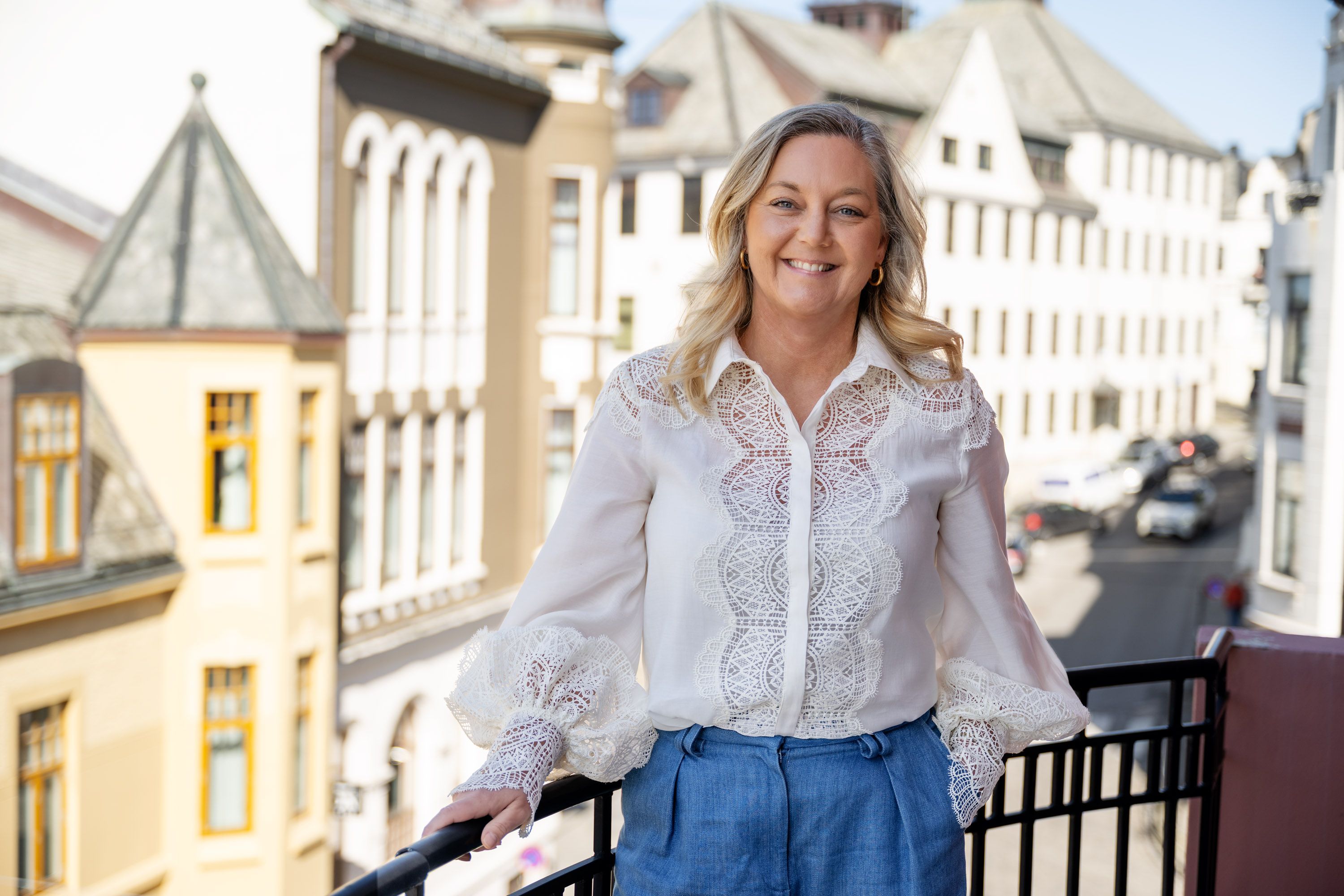 Linda Strømmen, divisjonsleder næringsliv i Sparebanken Møre, stående på en balkong i Ålesund sentrum.