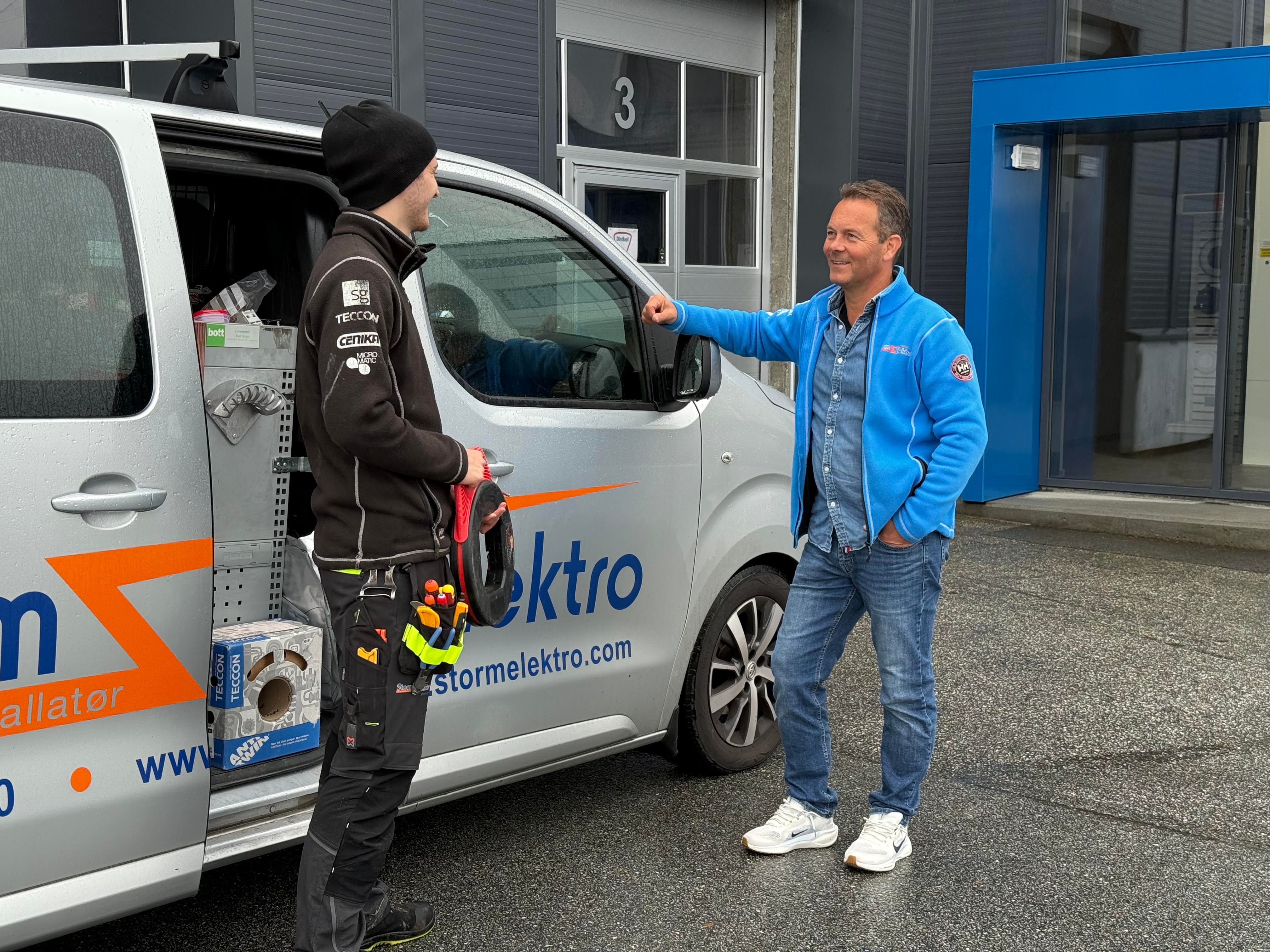 To menn ved arbeidsbil. 