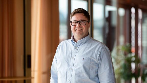 Stig Rune Sætre, leder for Handel og tjenesteytende næringer i Sparebanken Møre, smilende i moderne kontormiljø.