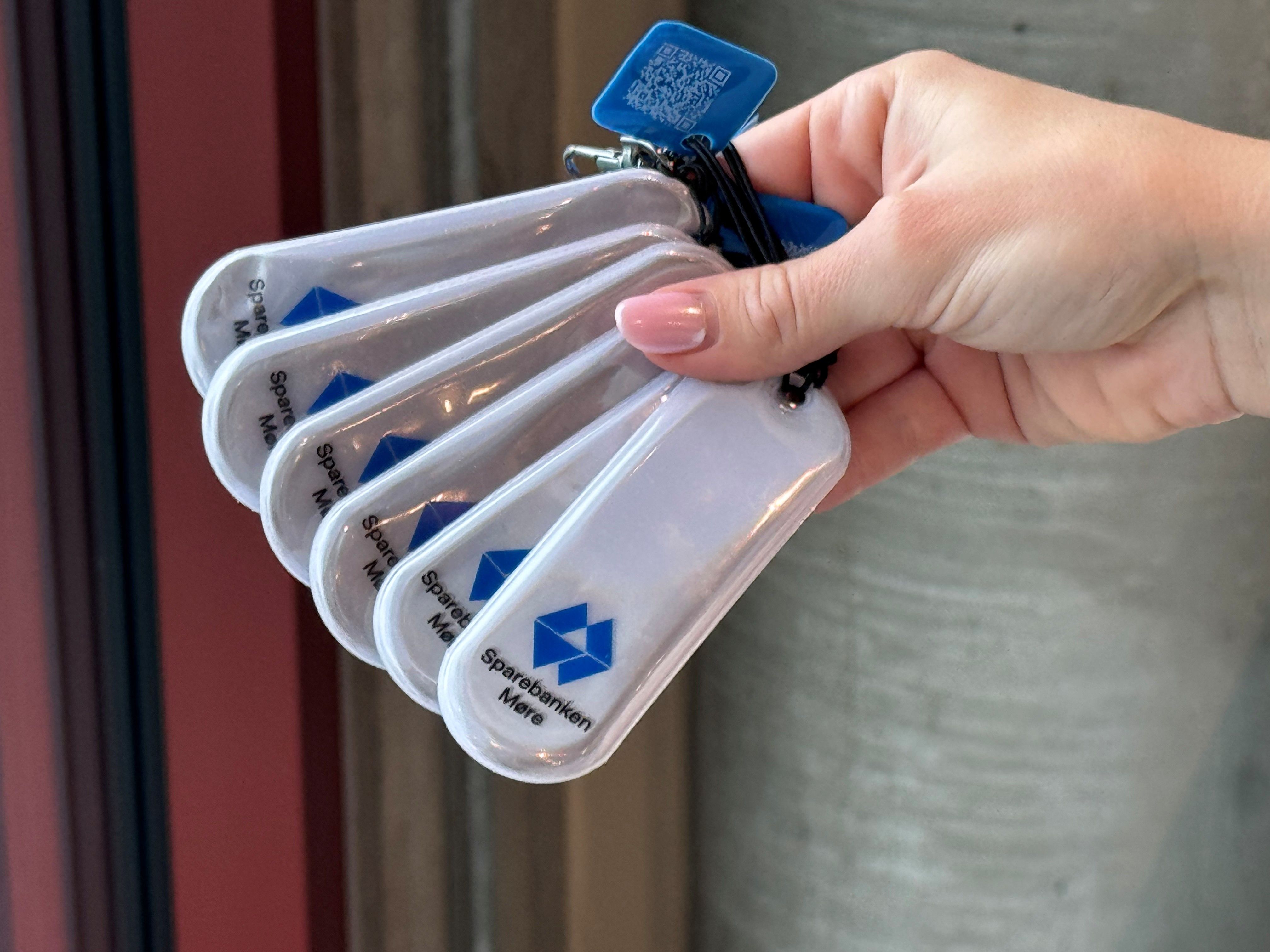 Kvinnehånd som holder6 refleksbrikker i en vifte.