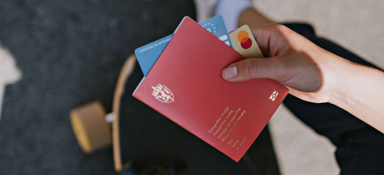 Hånd som holder pass og Mastercard