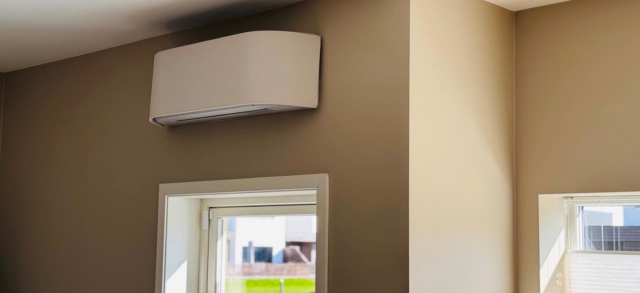Bilde av en varmepumpe i et hus med beige vegger og solskinn.