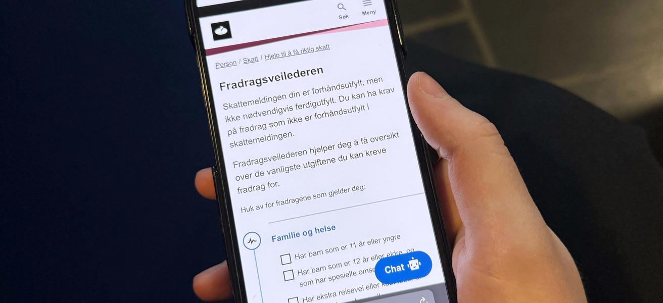 En hånd som holder en mobiltelefon som viser Skatteetaten sine nettsider.
