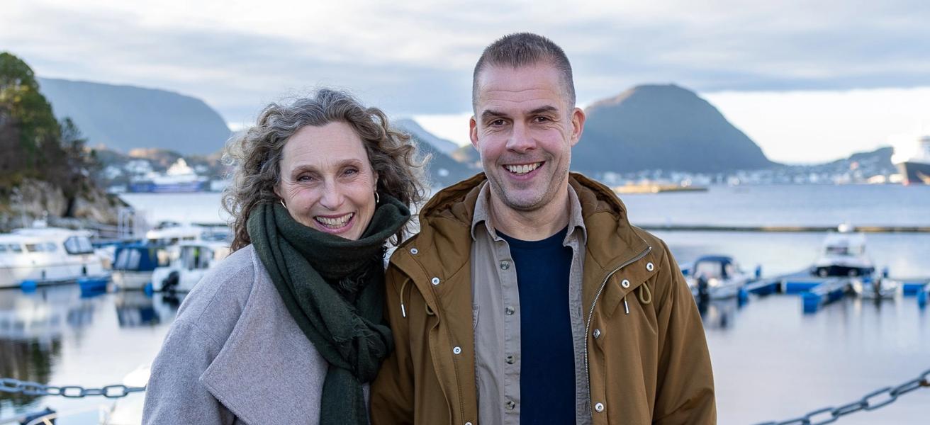 Mann og dame med ytterjakker som smiler i kamera.