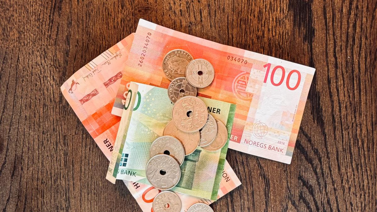 Barn som sitter på gulvet i mørket med en liten lampe foran seg.