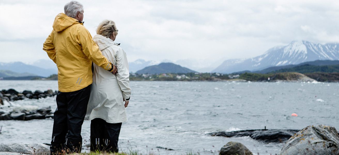 Eldre mann og dame ved havet, som ser ut over.