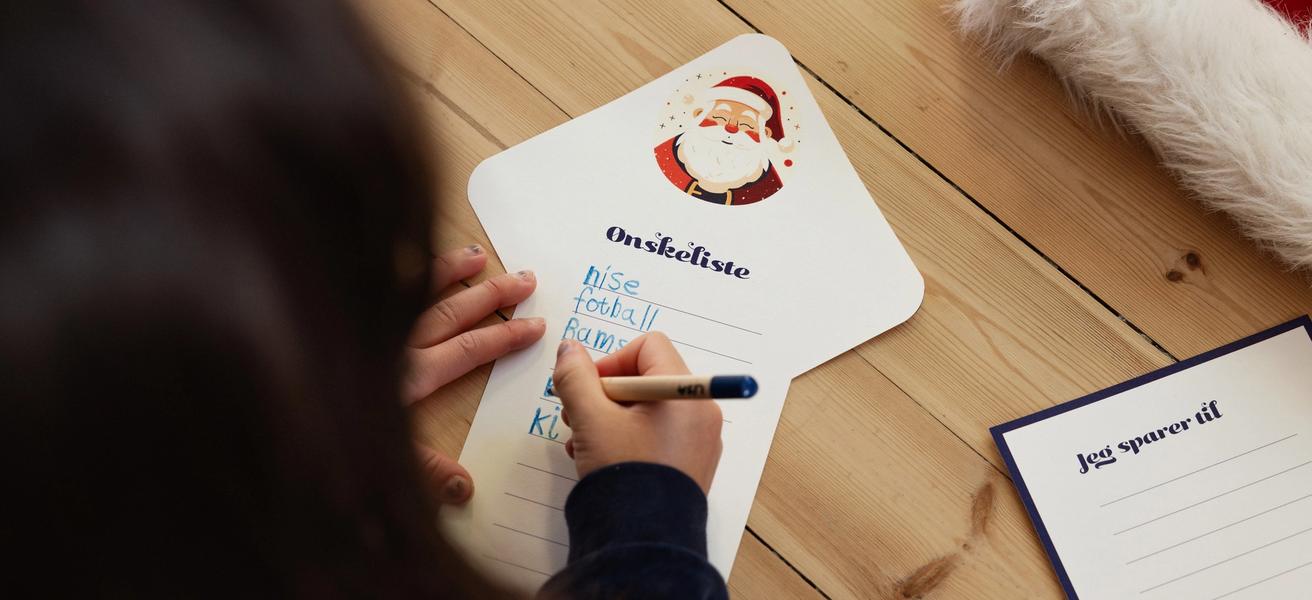 Jente med mørkt hår som skriver ønskeliste til jul