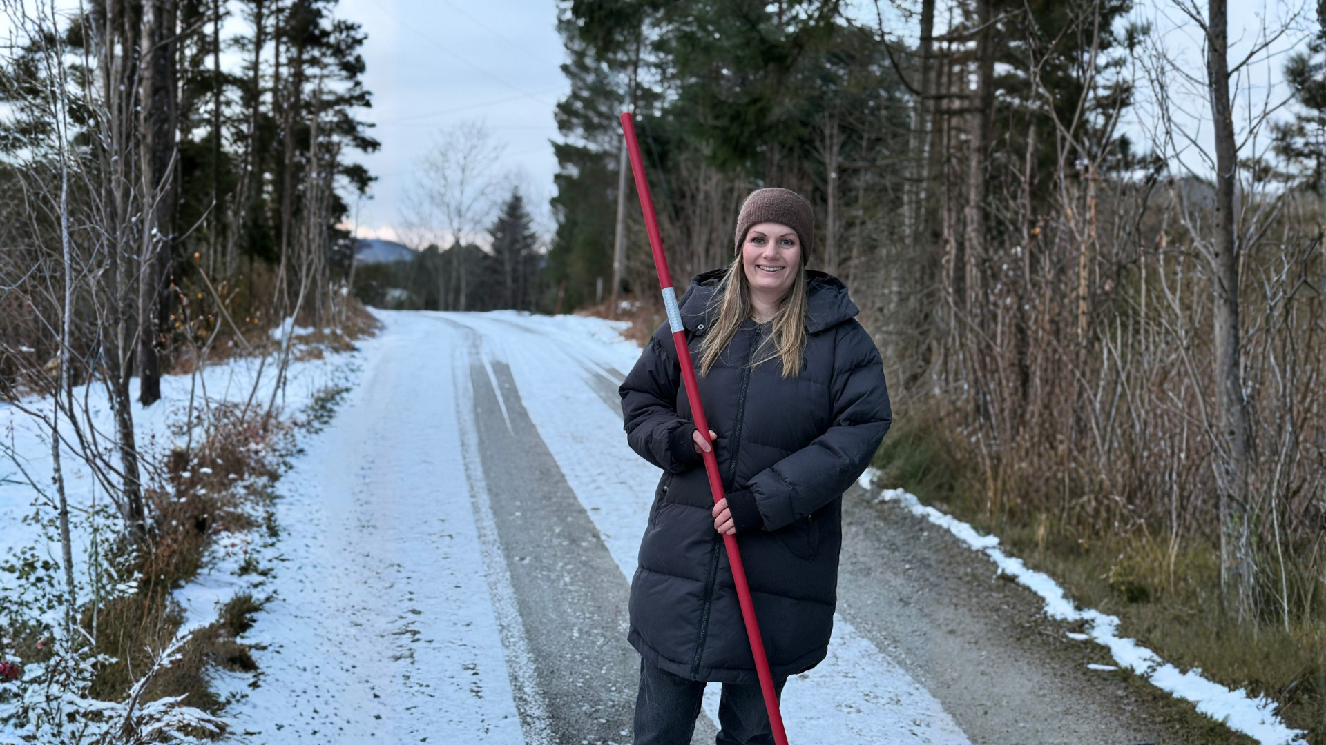 Daglig leder Elisabeth Pedersen Nerdal på vintervei, med brøytestikke i hånden.