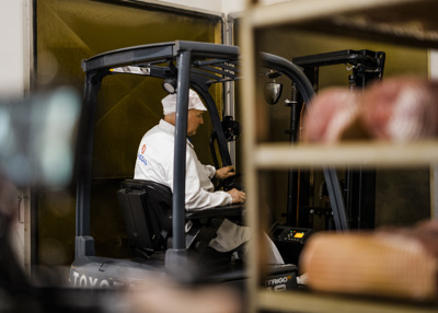 Person i arbeidsklær kjører en truck.
