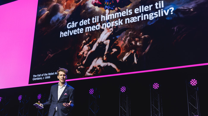 Runar fra Virke foran stor skjerm med kunstverk og norsk tekst om næringsliv, himmel og helvete.