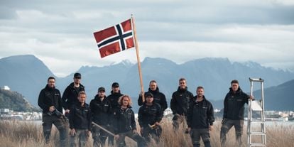 Bilde av ansatte i Snikkergutane som holder et norske flagg
