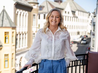 Linda Strømmen, divisjonsleder næringsliv i Sparebanken Møre, stående på en balkong i Ålesund sentrum.