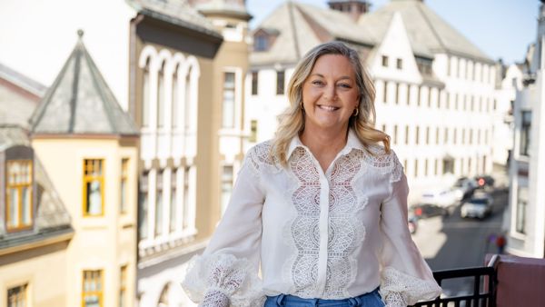Linda Strømmen, divisjonsleder næringsliv i Sparebanken Møre, stående på en balkong i Ålesund sentrum.