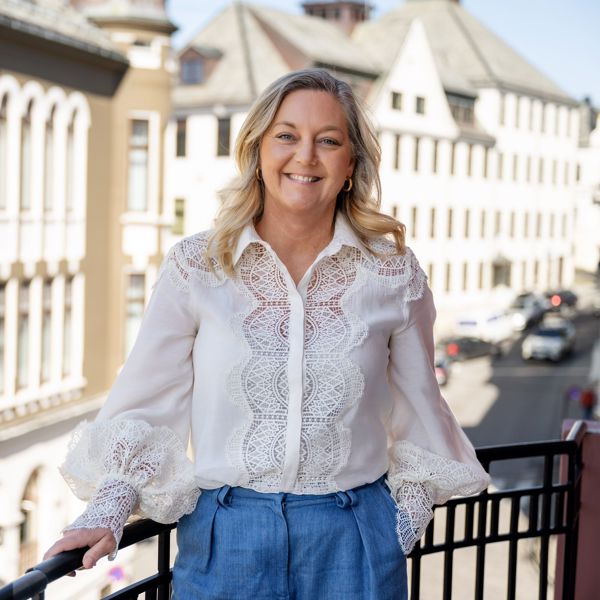 Linda Strømmen, divisjonsleder næringsliv i Sparebanken Møre, stående på en balkong i Ålesund sentrum.