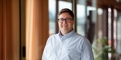 Stig Rune Sætre, leder for Handel og tjenesteytende næringer i Sparebanken Møre, smilende i moderne kontormiljø.