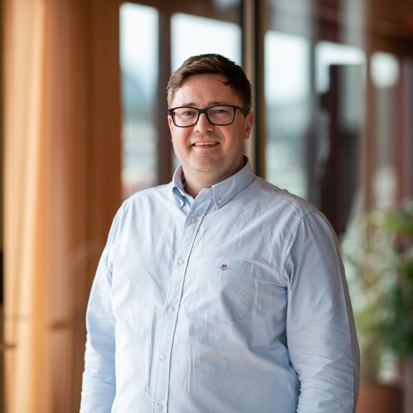 Stig Rune Sætre, leder for Handel og tjenesteytende næringer i Sparebanken Møre, smilende i moderne kontormiljø.