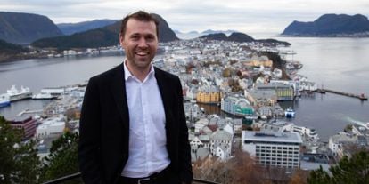 Jan Tore Holen smiler foran utsikt over Ålesunds bysentrum og fjordlandskap