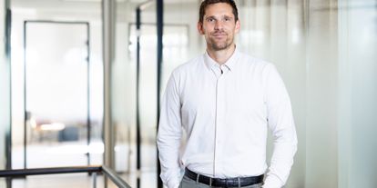 Mann i skjorte smiler i kamera