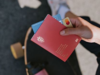 Hånd som holder pass og Mastercard