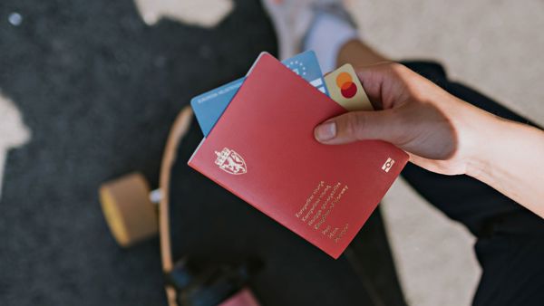 Hånd holder pass og kredittkort