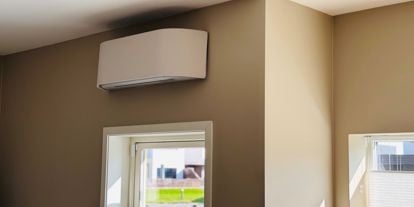 Bilde av en varmepumpe i et hus med beige vegger og solskinn.