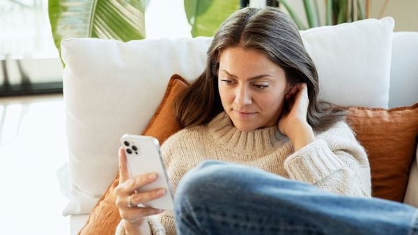 Dame i sofa med mobilen. Rolige omgivelser. 