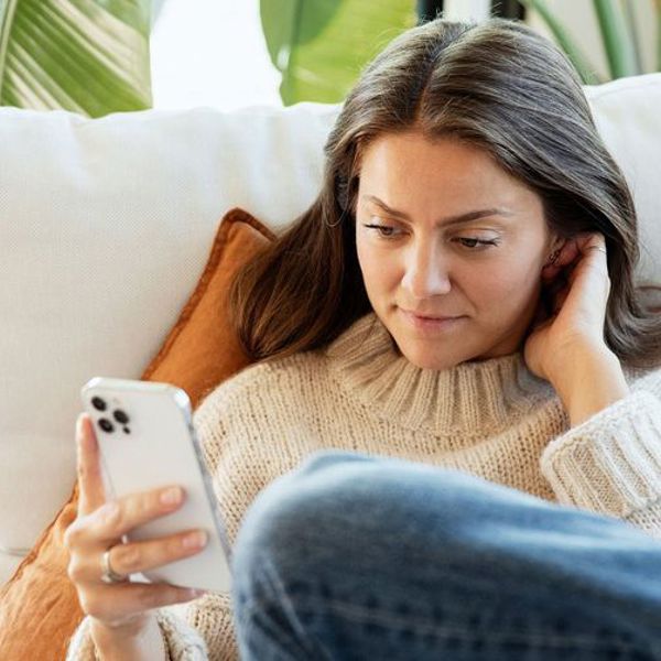 Dame i sofa med mobilen. Rolige omgivelser. 