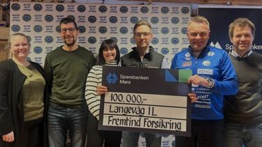 6 personer som står sammen fremfor en fotovegg. Holder en sjekk som viser 100.00 kroner fra Fremtind Forsikring. 