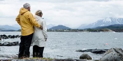 Eldre mann og dame ved havet, som ser ut over. 