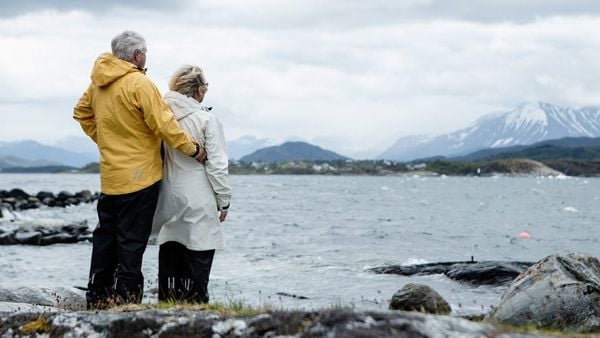 Eldre mann og dame ved havet, som ser ut over. 
