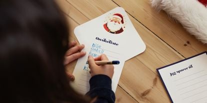 Jente med mørkt hår som skriver ønskeliste til jul 