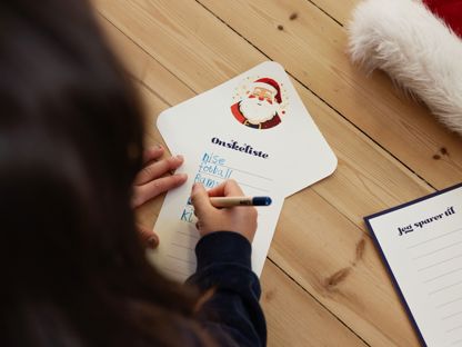 Jente med mørkt hår som skriver ønskeliste til jul 