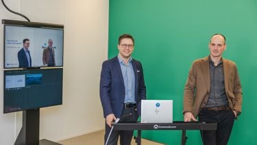 To menn fremfor en greenscreen med to skjermer i bakgrunn. 