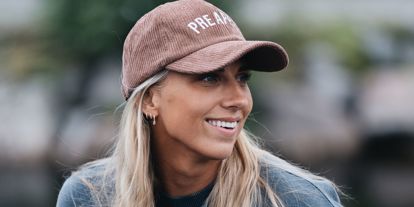 Jente med langt lyst hår og rosa caps