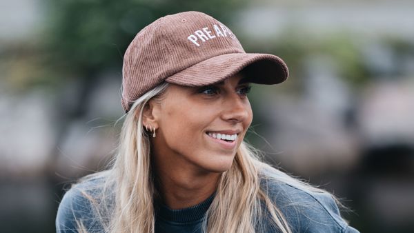 Jente med langt lyst hår og rosa caps