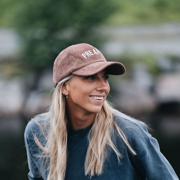 Jente med langt lyst hår og rosa caps