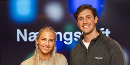 Kvinne og mann som ser i kamera og smiler. Næringsteft står på en skjerm bak. 