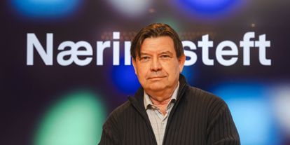 Mann med skjorte og jakke utenpå. Ser i kamera. Bak er det skjerm som står Næringsteft på. 