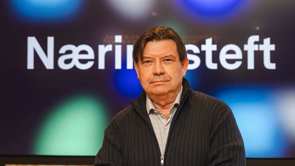 Mann med skjorte og jakke utenpå. Ser i kamera. Bak er det skjerm som står Næringsteft på. 