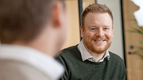 Odd Ivar Hjelvik, finansiell rådgiver i Næringsbasen, i samtale med kollega i et kontormiljø