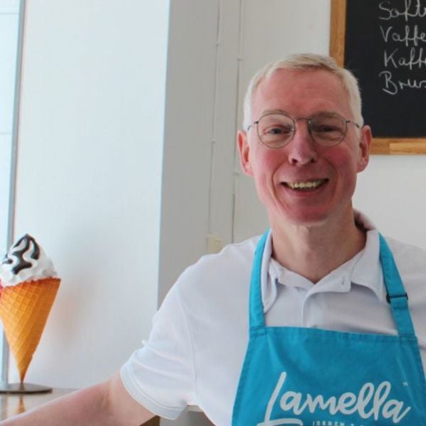 Dirk Kiefer smiler bak disken i iskrembaren Lamella, iført blått forkle med logoen.