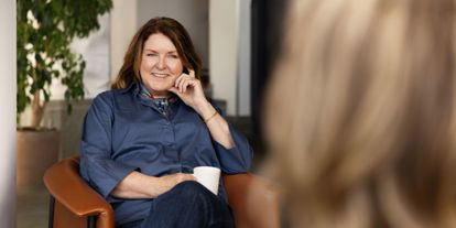 Hege Longva, daglig leder i NOA, sitter i en stol og smiler under en samtale i kontorlokaler.