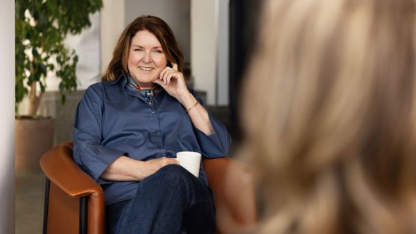 Hege Longva, daglig leder i NOA, sitter i en stol og smiler under en samtale i kontorlokaler.
