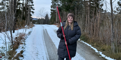 Daglig leder Elisabeth Pedersen Nerdal på vintervei, med brøytestikke i hånden.