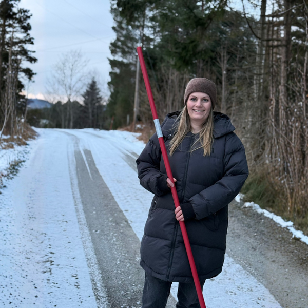Daglig leder Elisabeth Pedersen Nerdal på vintervei, med brøytestikke i hånden.