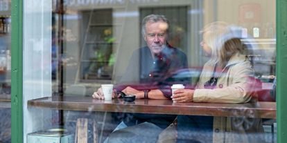 Mann og dame som sitter ved vindusplass på cafe