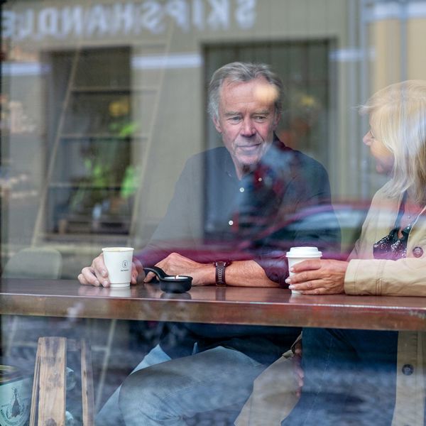 Mann og dame som sitter ved vindusplass på cafe