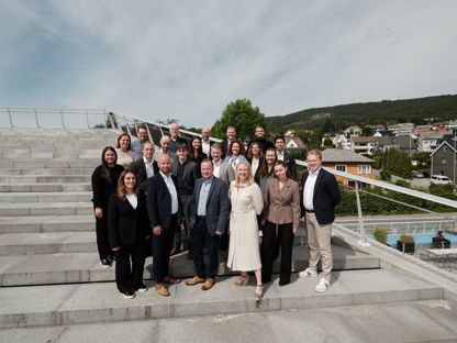 Bildet viser alle ansatte i Møremegling i en solfylt trapp, som smiler. 
