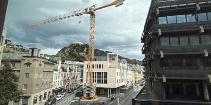 Sparebanken Møre sitt hovedkontor i Ålesund, med fjellstua i bakgrunn, og en stor kran i forkant. 